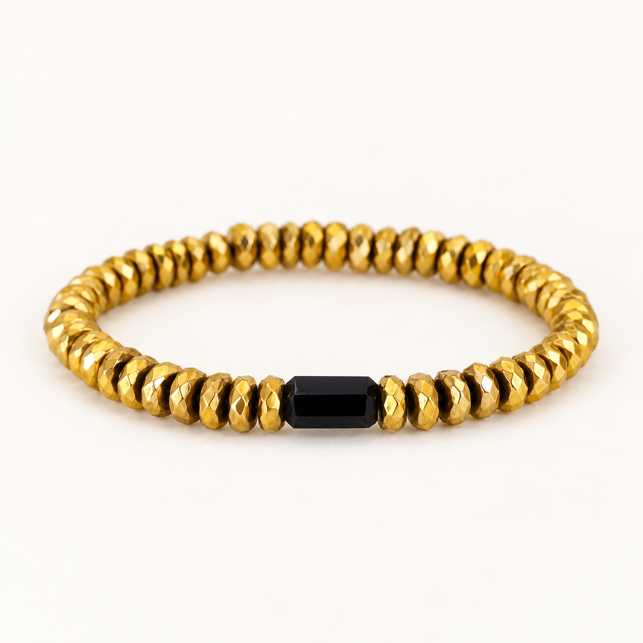 Gilded Light Bracelet, faceted gold-dipped Hematite with a single elongated Onyx